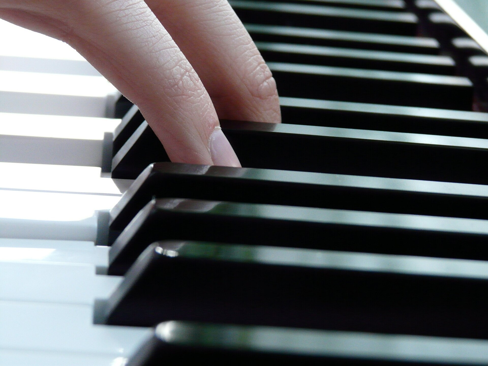 Hand resting on piano keys