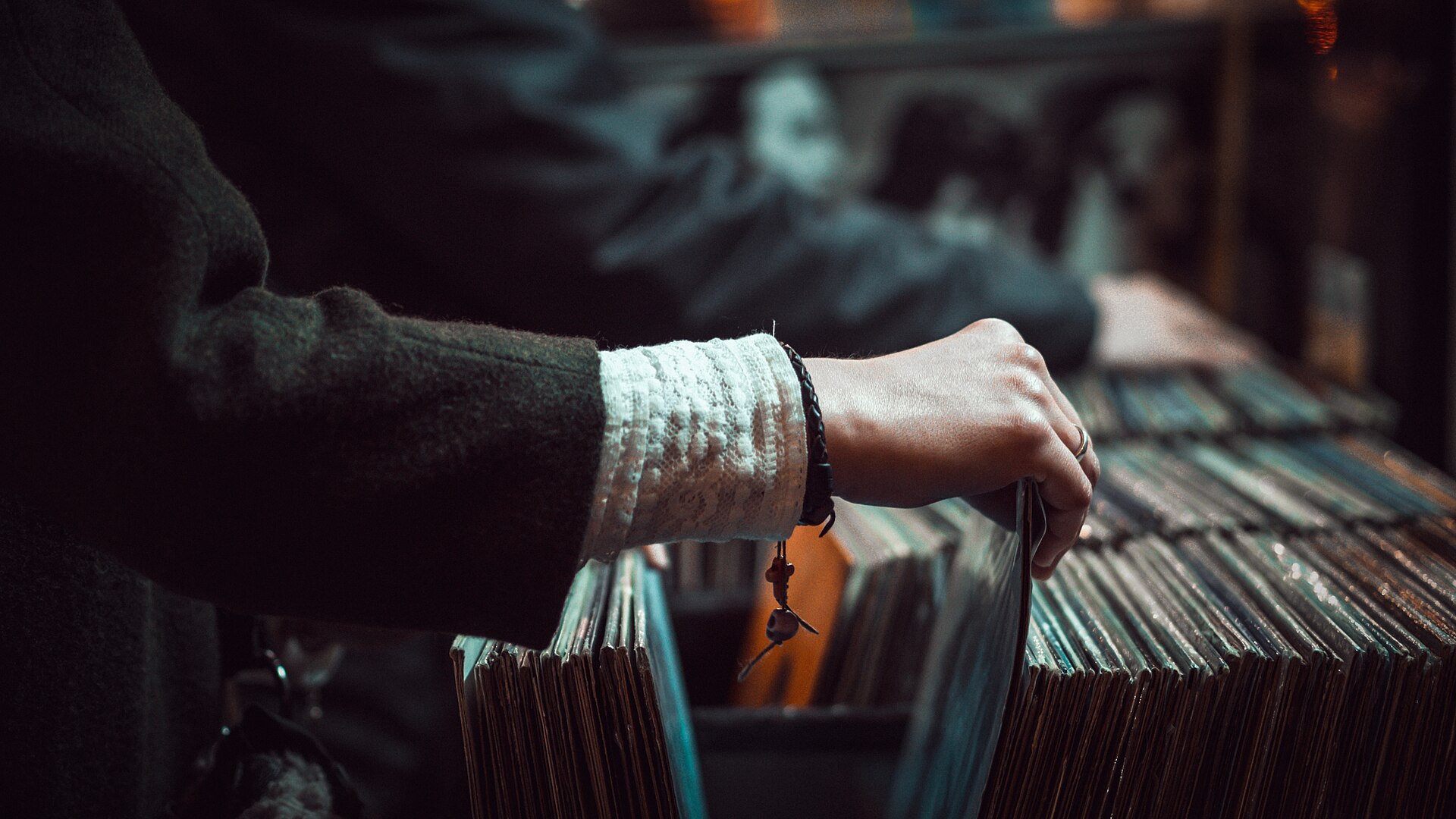 Hand flipping through a bin of vinyl records