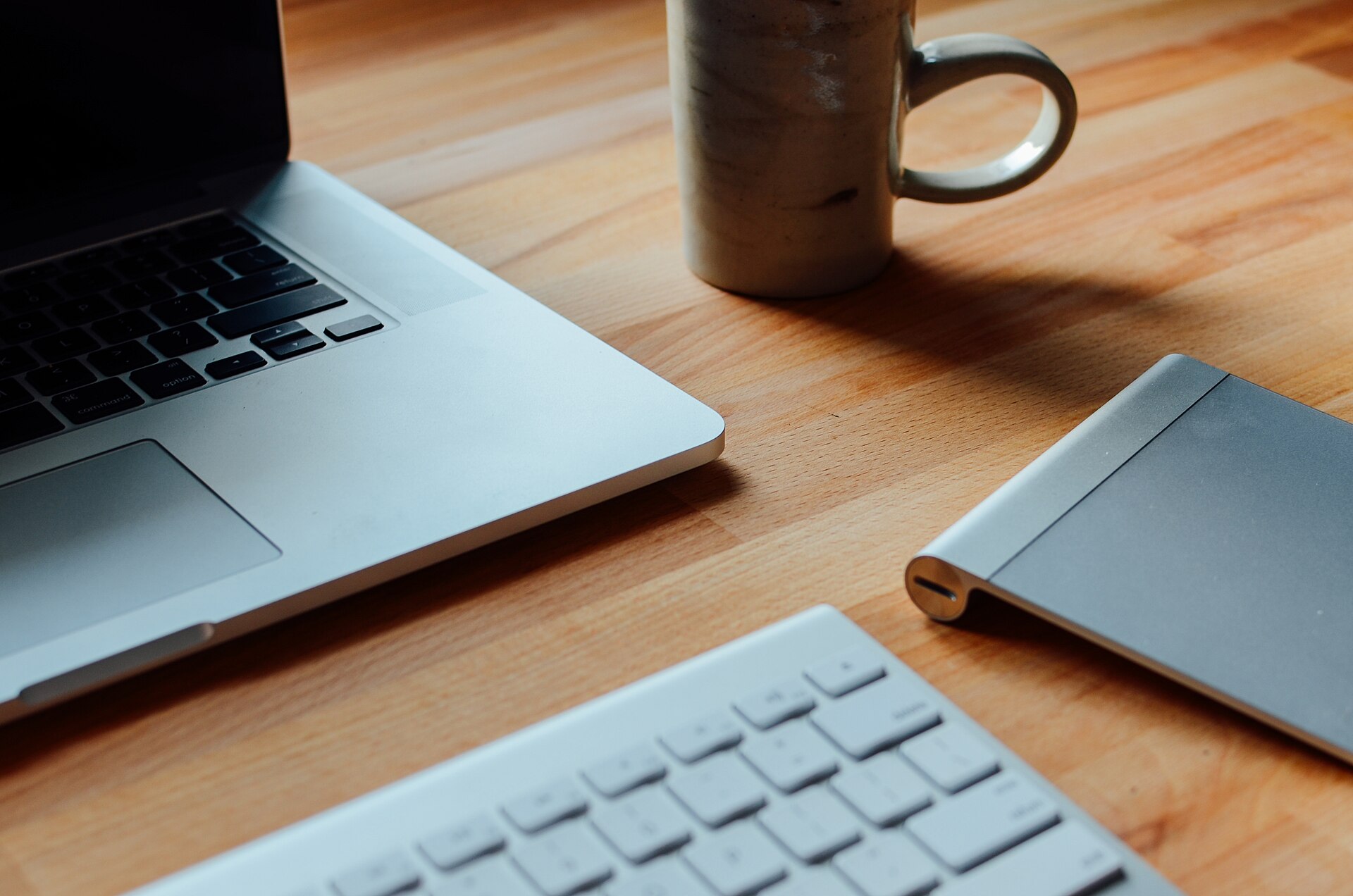 Laptop and coffee mug on a wooden desk